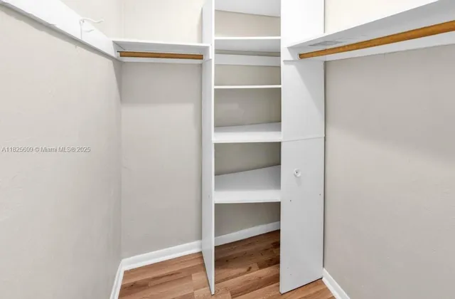 a view of walk in closet with empty racks