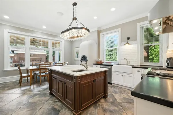 a kitchen with a stove a sink a counter space dining table and chairs