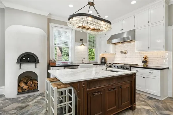 a kitchen with a sink a stove a clock and cabinets