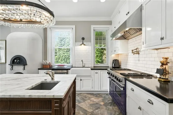 a kitchen with granite countertop a sink a stove and cabinets