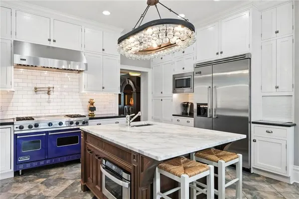 a kitchen with stainless steel appliances granite countertop a stove a sink dishwasher and a refrigerator