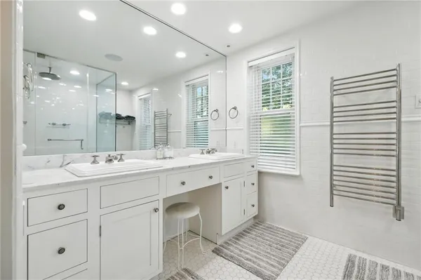 a bathroom with a double vanity sink a mirror and a bathtub