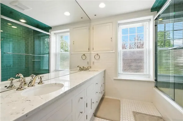 a bathroom with a tub sink and mirror