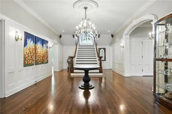a view of a hallway with wooden floor windows and a chandelier