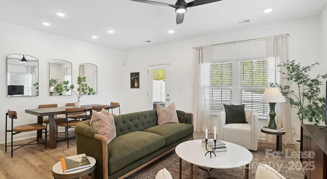 a living room with furniture and a wooden floor