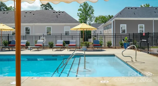 a swimming pool view with a seating space and a garden view