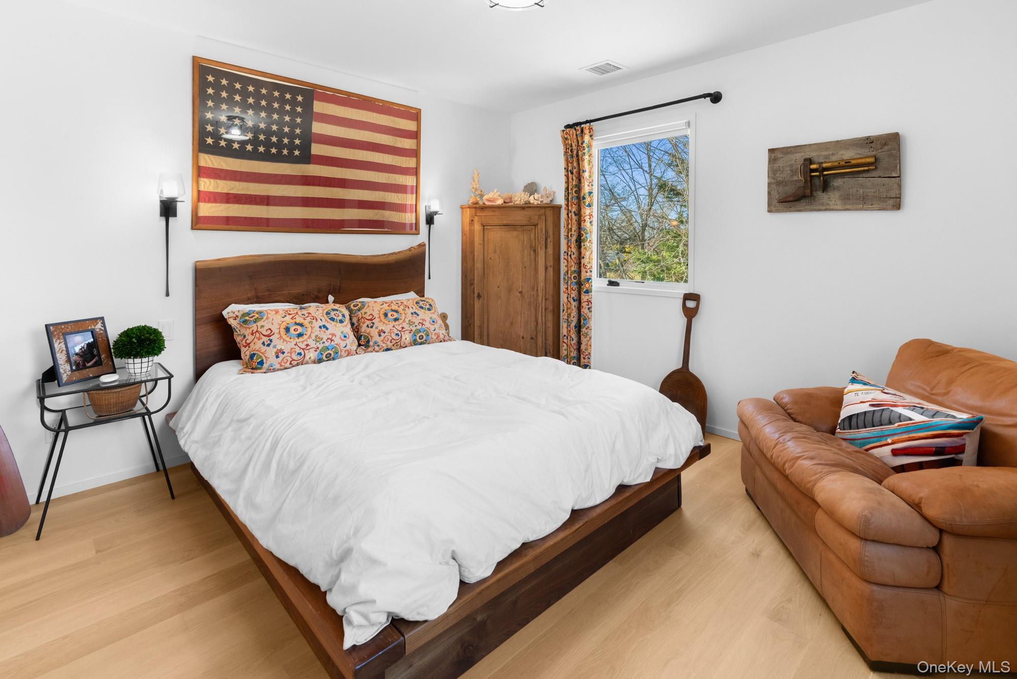238 Sebonac Road Southampton, NY 11968 - Photo 14 of 23 a bedroom with a bed and wooden floor