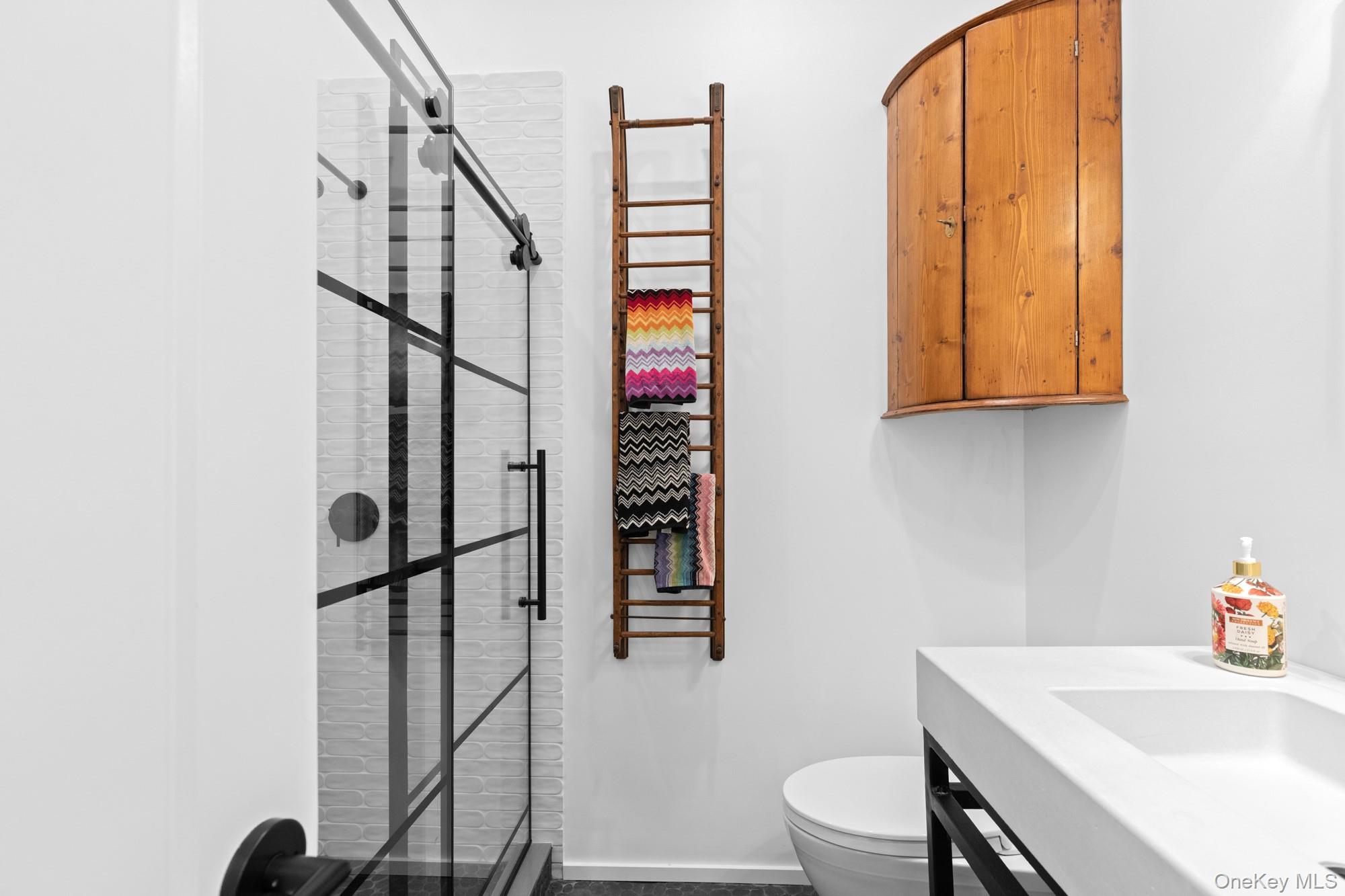 238 Sebonac Road Southampton, NY 11968 - Photo 15 of 23 a bathroom with a sink a toilet and shower
