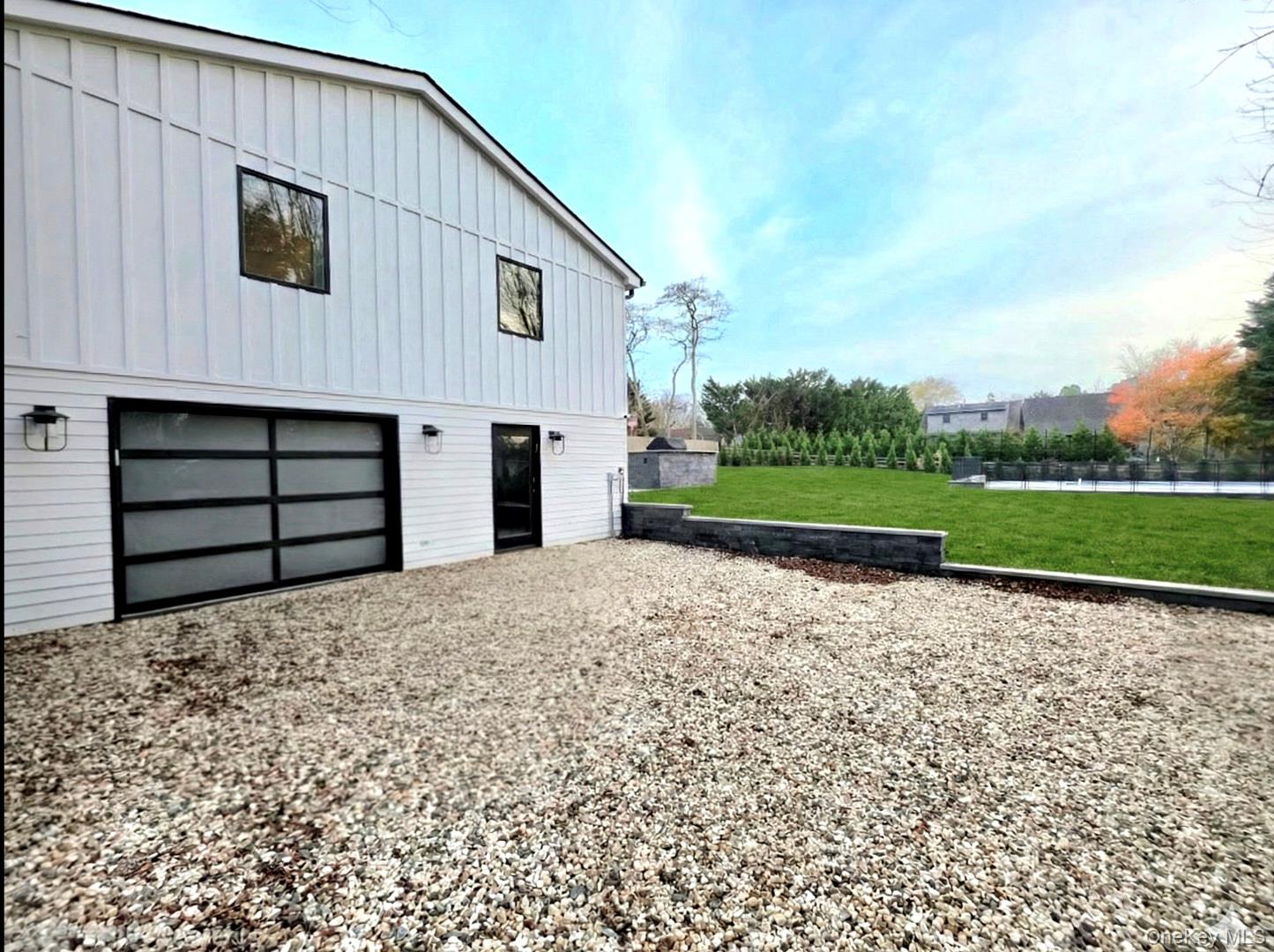 238 Sebonac Road Southampton, NY 11968 - Photo 22 of 23 a front view of a house with a yard and garage