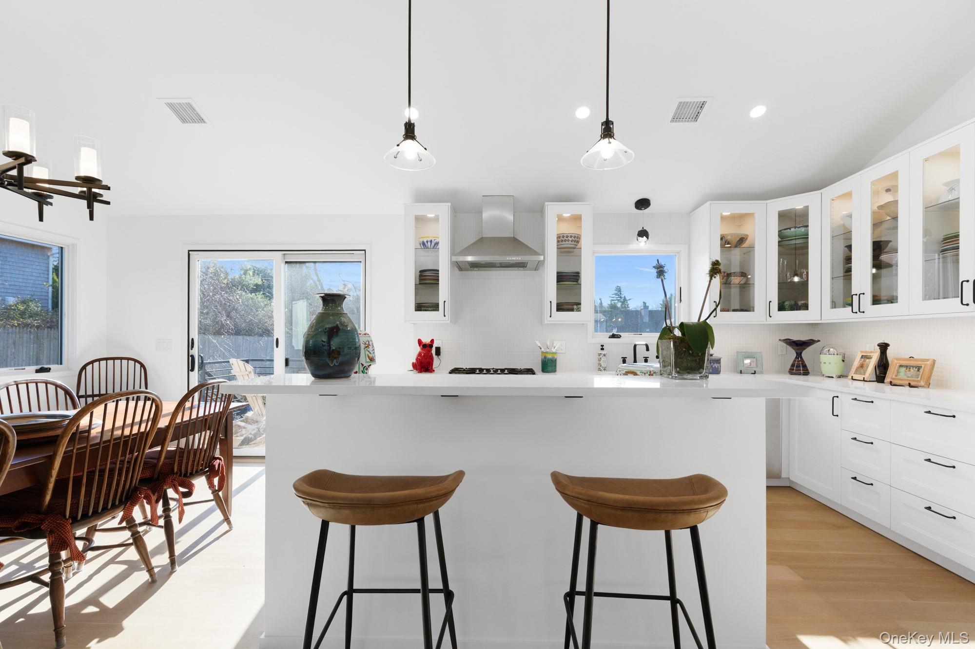 238 Sebonac Road Southampton, NY 11968 - Photo 7 of 23 a kitchen with stainless steel appliances a table chairs and a refrigerator