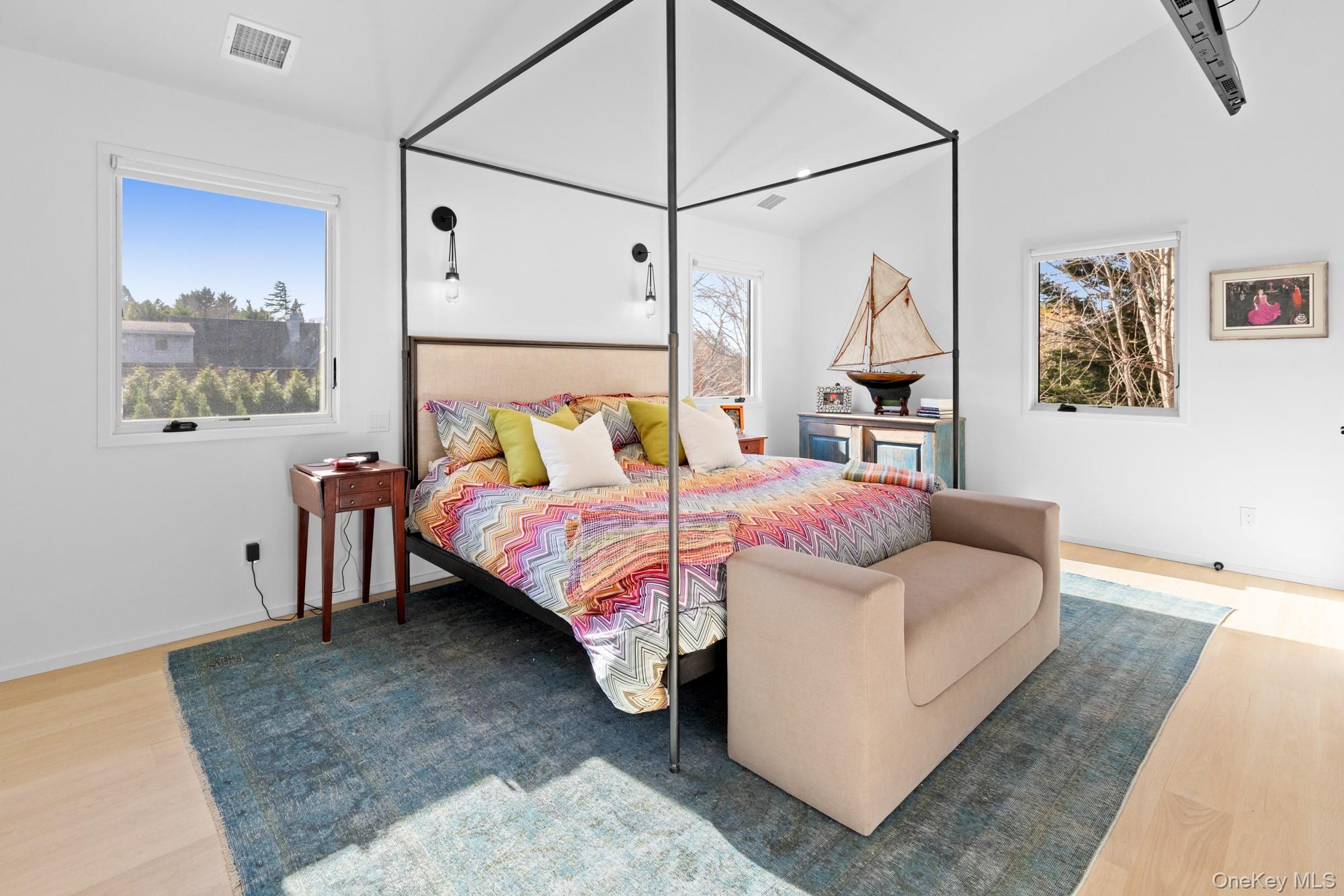 238 Sebonac Road Southampton, NY 11968 - Photo 10 of 23 a bedroom with a bed table and wall painting