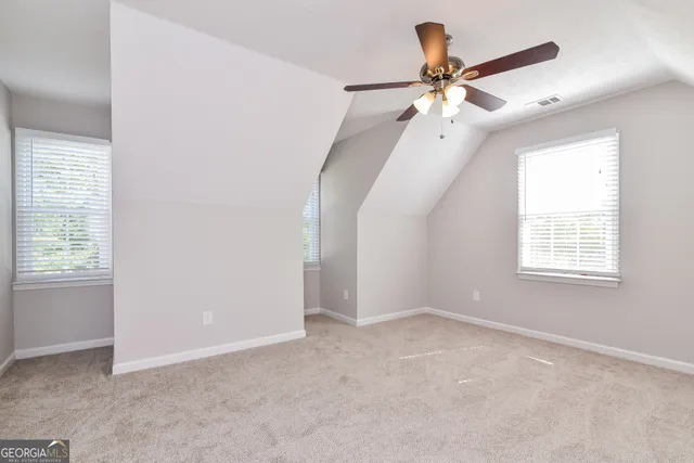 an empty room with fan and windows