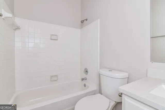 a white toilet sitting next to a bath tub