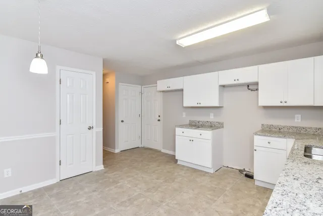 a kitchen with cabinets stove top oven and sink