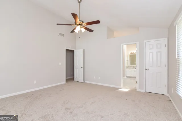 an empty room with a fan and a window
