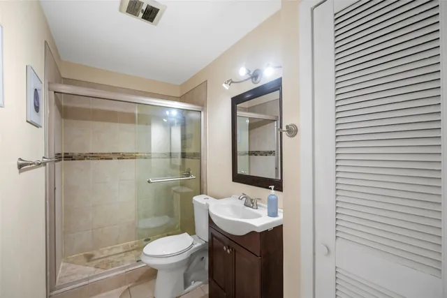 a bathroom with a granite countertop toilet a sink and a shower