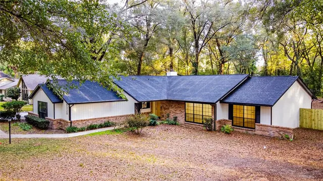 a view of a yard with a small house and wooden fence