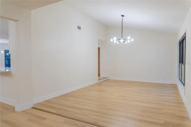 a view of a room with wooden floor and chandelier