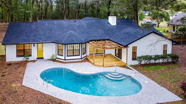 an aerial view of residential houses with outdoor space and trees
