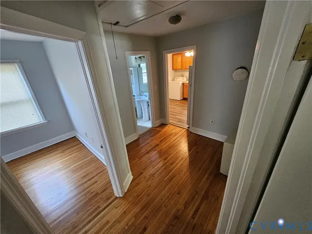 a view of a hallway with wooden floor and stairs