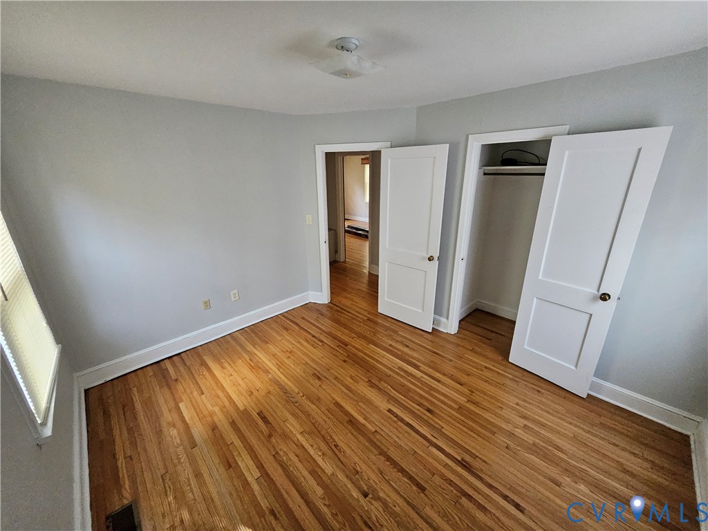 305 5th Street Blackstone, VA 23824 - Photo 8 of 12 a view of an empty room with wooden floor and a window