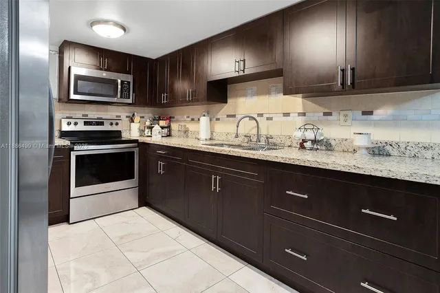 a kitchen with stainless steel appliances granite countertop a sink stove and microwave