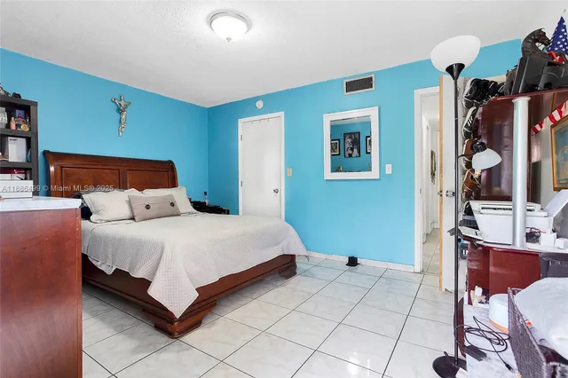 a bedroom with a bed and a large mirror