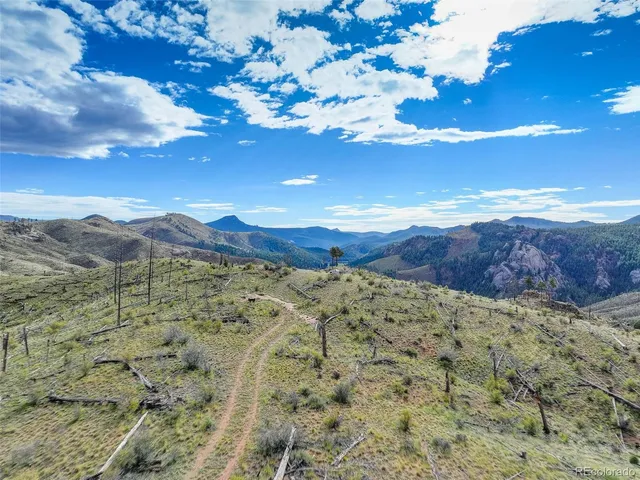 a view of a dry yard with mountain and lake view