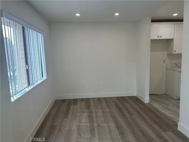 an empty room with wooden floor and a window
