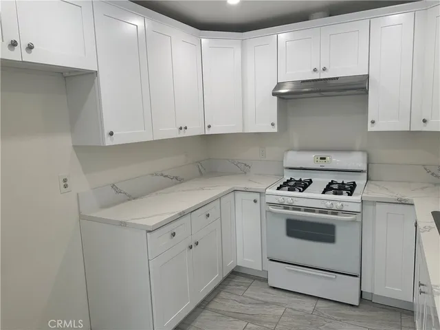 a kitchen with white cabinets and white appliances