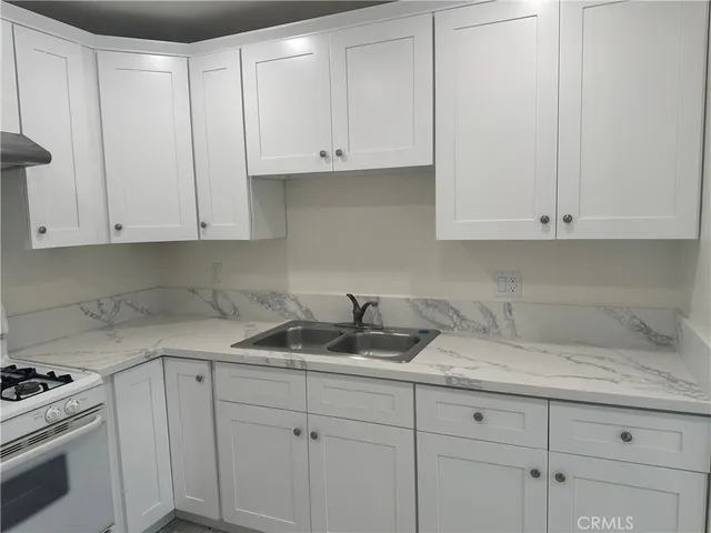 a kitchen with white cabinets and a stove