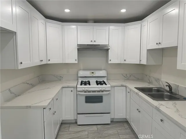 a kitchen with white cabinets and white appliances