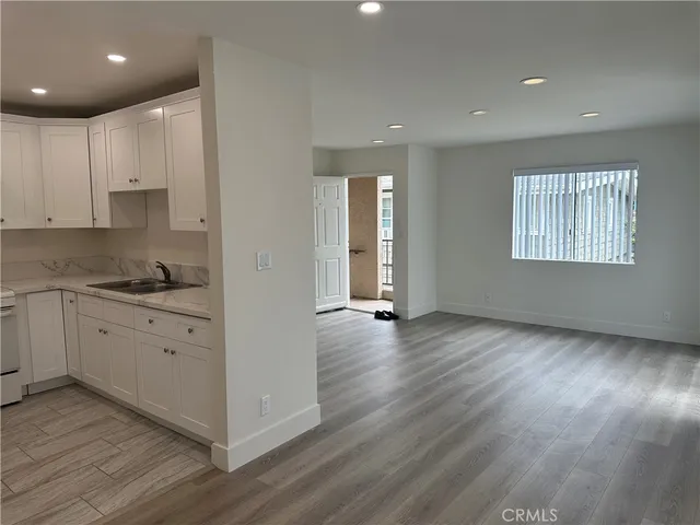 a view of a kitchen with wooden floor and windows in it