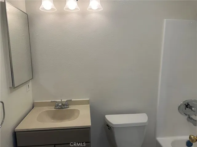 a bathroom with a sink toilet and mirror