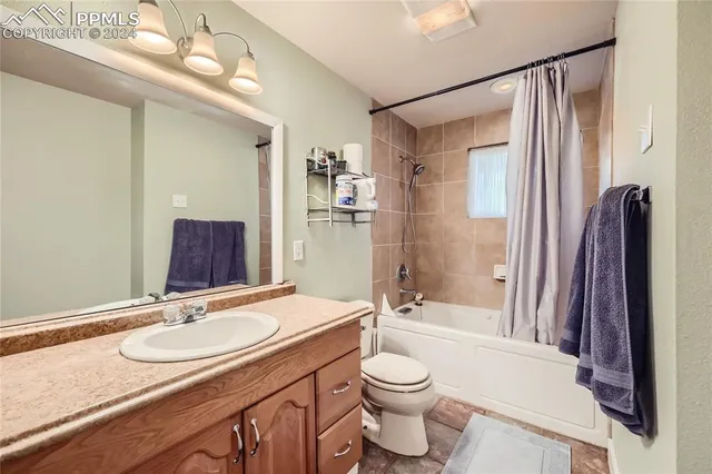 a bathroom with a sink a toilet a mirror and shower