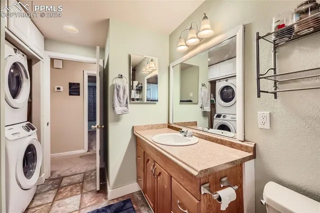 a utility room with dryer washer and a view of living room