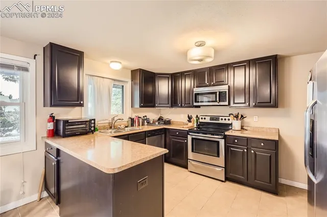 a kitchen with stainless steel appliances granite countertop a sink stove microwave and refrigerator