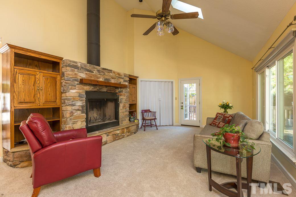 4004 Sherlock Court Raleigh, NC 27613 - Photo 3 of 11 Spacious LIVING ROOM with WOOD BURNING FIREPLACE with GAS STARTER, VAULTED CEILING SKYLIGHTS, and TRIPLE PANED WINDOWS overlooking SPACIOUS DECK and a FENCED BACKYARD.