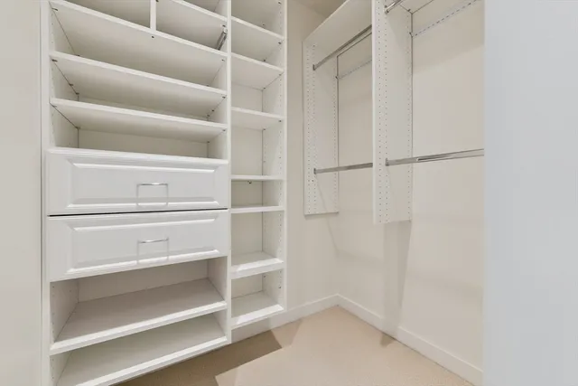 a view of walk in closet with empty racks