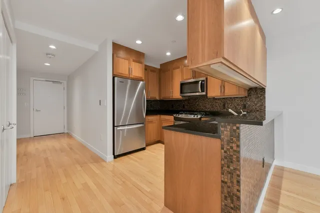 a kitchen with stainless steel appliances granite countertop a refrigerator and a stove