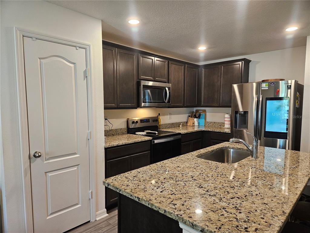 2309 Rio Grande Forest Lane Kissimmee, FL 34759 - Photo 4 of 12 a kitchen with granite countertop stainless steel appliances and wooden cabinets