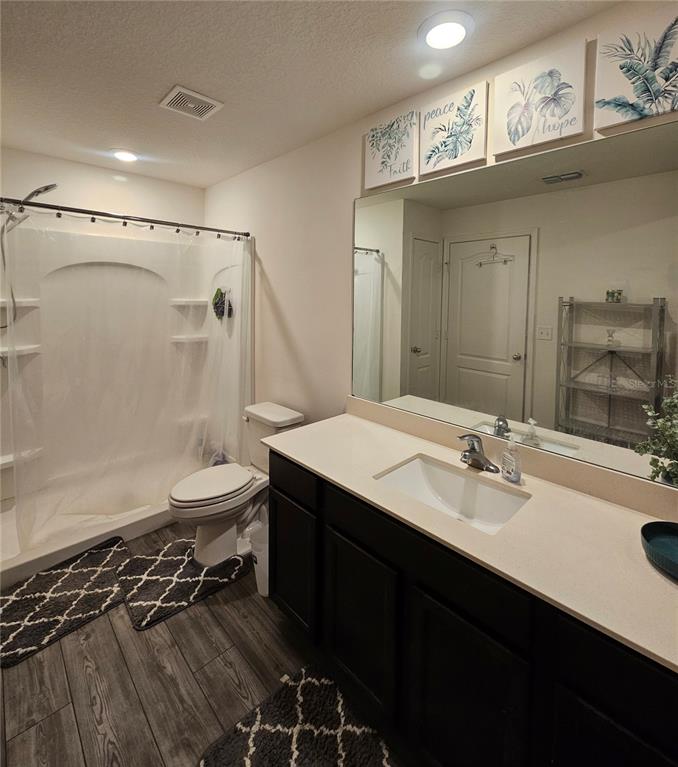 2309 Rio Grande Forest Lane Kissimmee, FL 34759 - Photo 9 of 12 a bathroom with a sink a toilet a mirror and shower