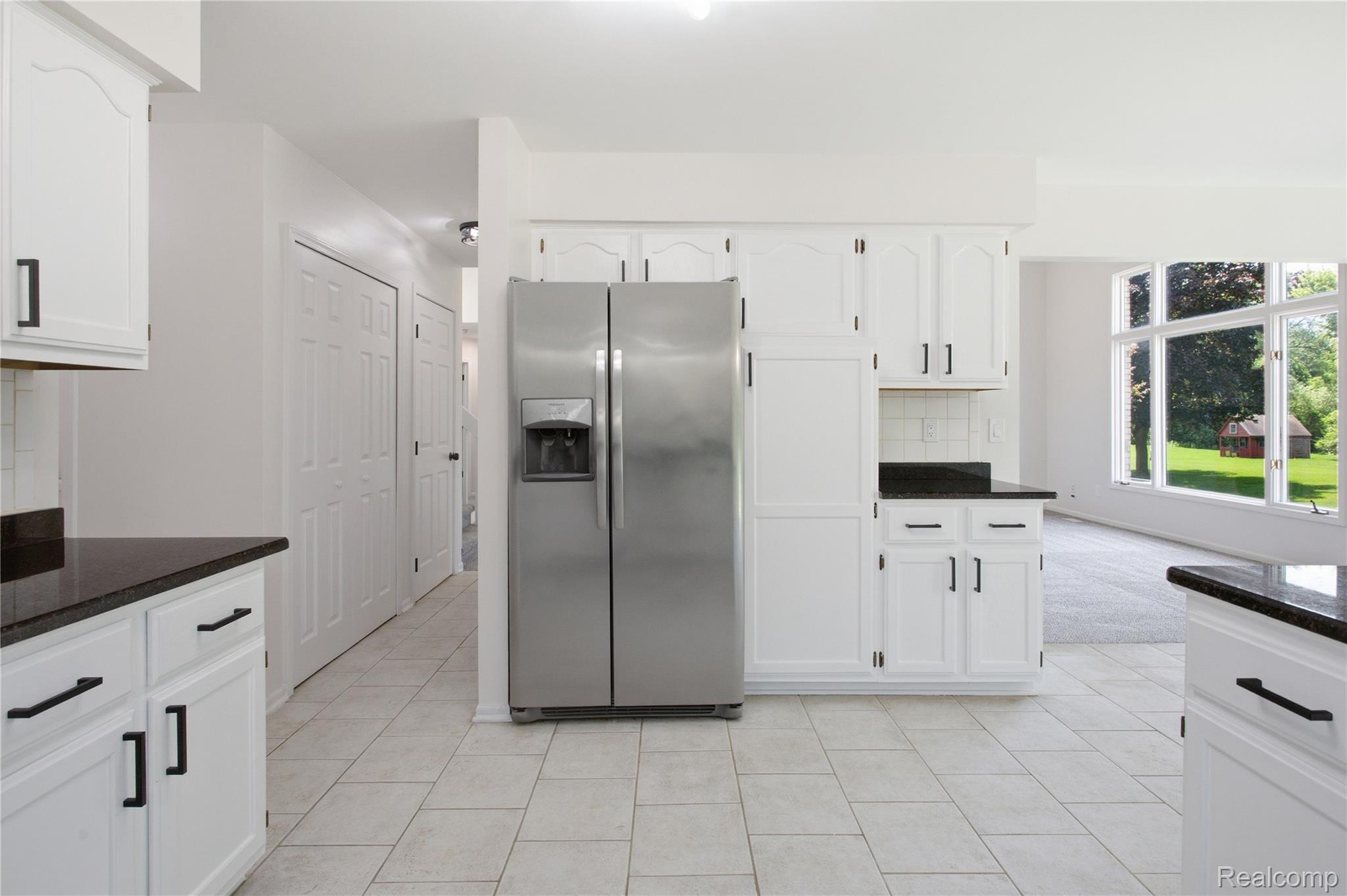 52658 Stag Ridge Drive Macomb, MI 48042 - Photo 10 of 28 Kitchen featuring extensive white cabinetry, dark countertops, and tile flooring