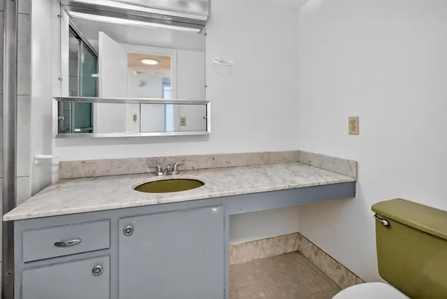 a bathroom with a granite countertop sink and a mirror