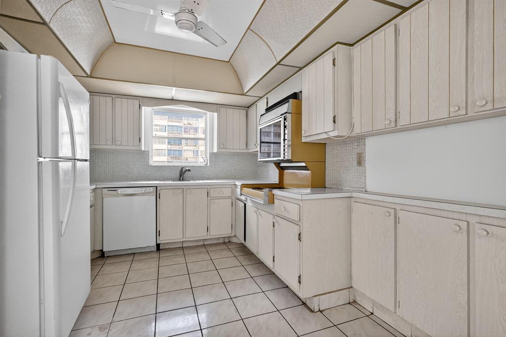 2750 Northeast 183rd Street, Unit 911 Aventura, FL 33160 - Photo 25 of 34 a kitchen with white cabinets and white appliances