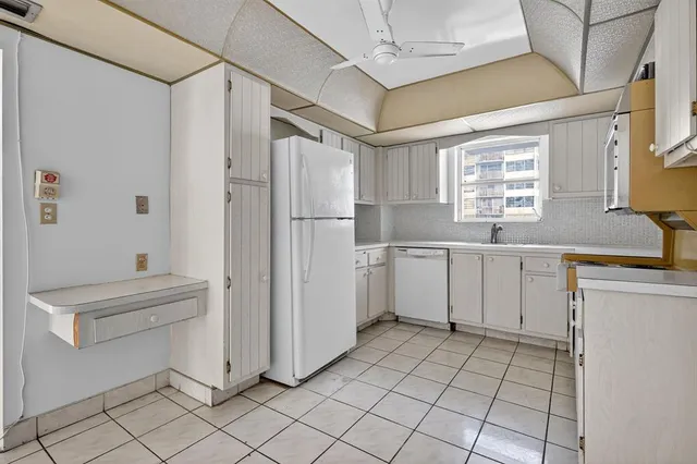a kitchen with white cabinets and white appliances