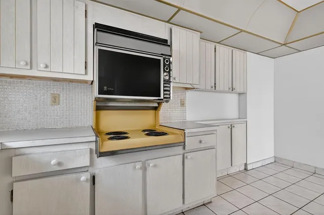 a kitchen with white cabinets and white appliances