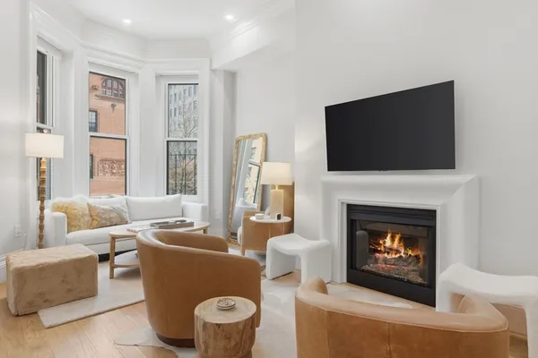 a living room with furniture a fireplace and a flat screen tv