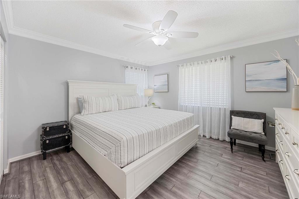 1155 Sandpiper Street, Unit G6 Naples, FL 34102 - Photo 14 of 30 a bedroom with a bed and a chair