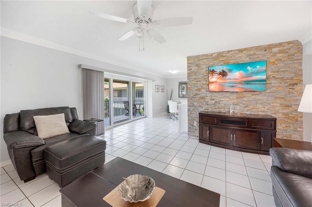 1155 Sandpiper Street, Unit G6 Naples, FL 34102 - Photo 6 of 30 a living room with furniture and a fireplace